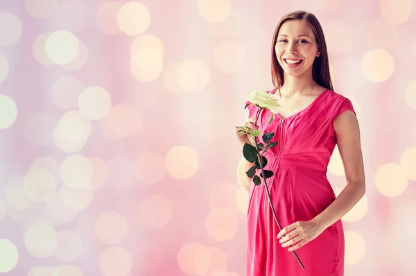 Glad gravid kvinna med rosa blomma — Stockfoto