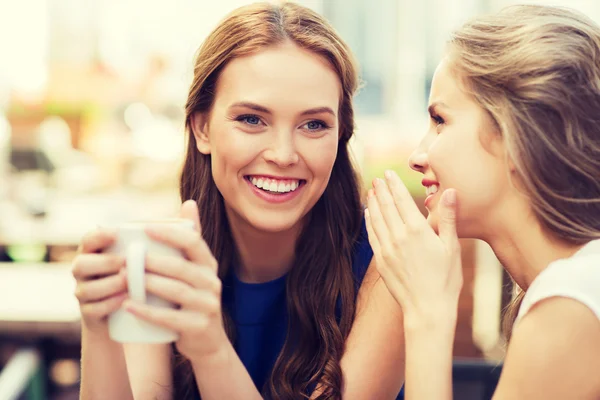 Young women drinking coffee and talking at cafe — Stock Photo, Image