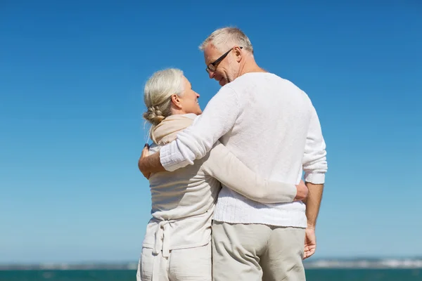 Gelukkige senior paar knuffelen op zomer strand — Stockfoto