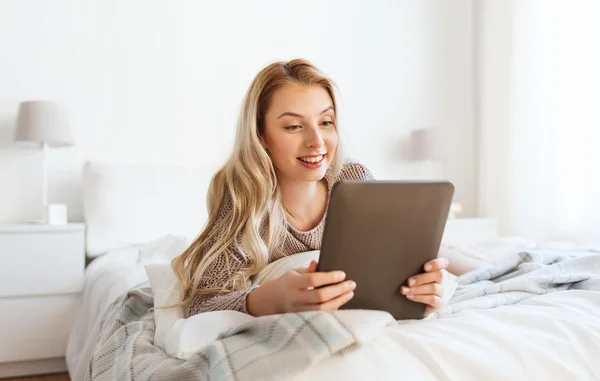 Feliz joven con la tableta de la PC en la cama en casa —  Fotos de Stock