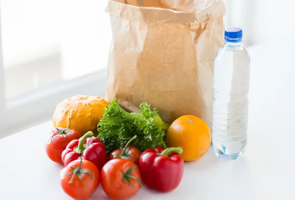 Close up de saco de papel com legumes e água — Fotografia de Stock