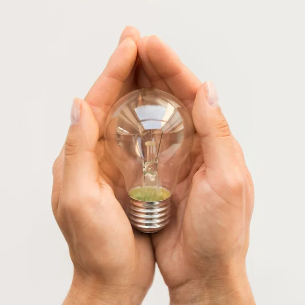 Close up of hands holding edison lamp or lightbulb — Stock Photo, Image