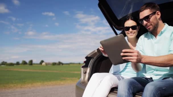 Casal feliz com tablet pc no porta-malas carro hatchback 37 — Vídeo de Stock