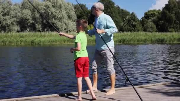 Grandfather and grandson fishing on river berth 2 — Stock Video