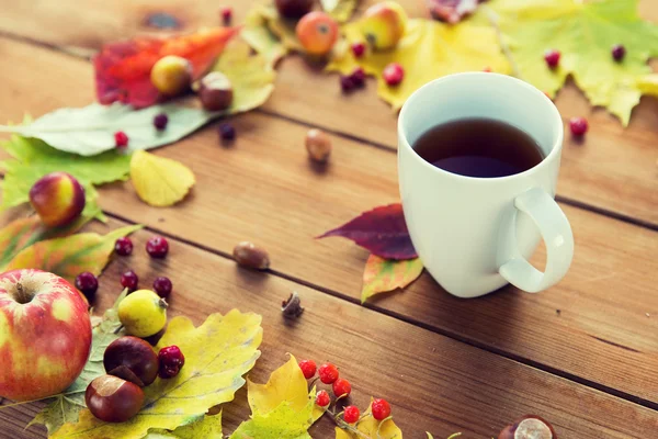 Primo piano di tazza di tè sul tavolo con foglie autunnali — Foto Stock