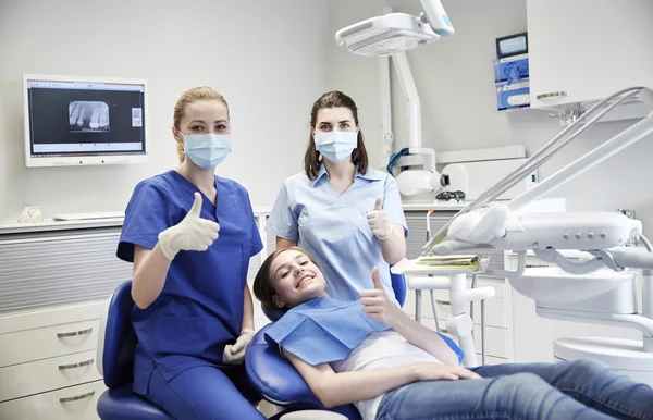 Dentista mujer feliz con chica paciente en la clínica — Foto de Stock