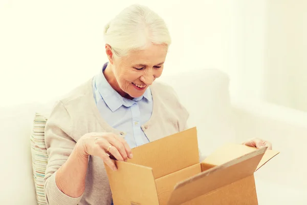 Щаслива старша жінка з посилкою вдома — стокове фото