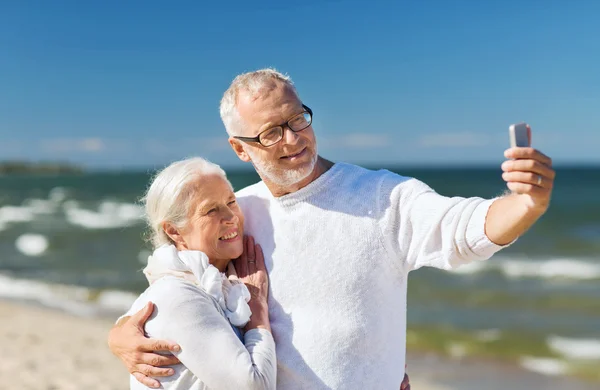 Lyckliga äldre par kramas på sommaren beach — Stockfoto