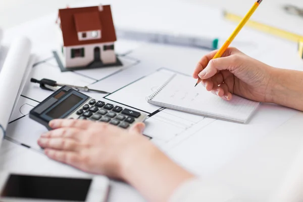 Close-up van de hand op de blauwdruk schrijven naar laptop — Stockfoto