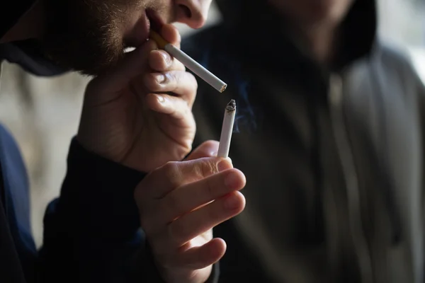 Primer plano de los jóvenes que fuman cigarrillos — Foto de Stock