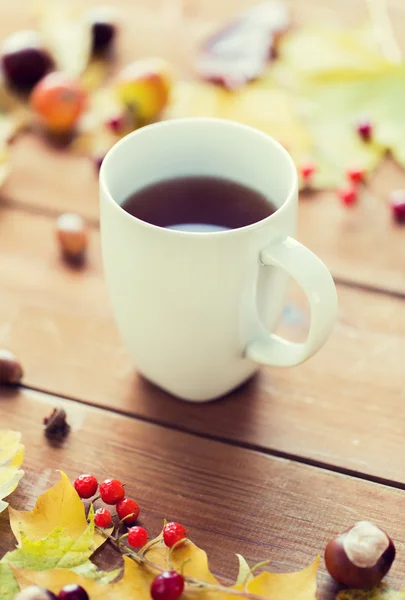 Primer plano de la taza de té en la mesa con hojas de otoño — Foto de Stock