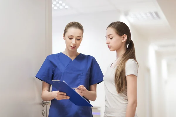 Врач или медсестра с планшетом и пациенткой — стоковое фото
