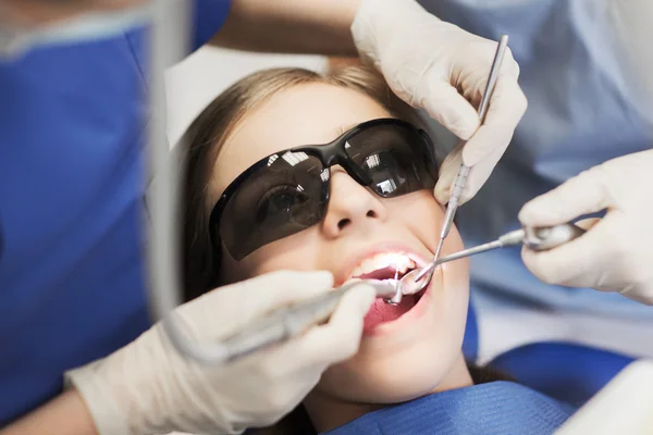 Female dentists treating patient girl teeth — Stock Photo, Image