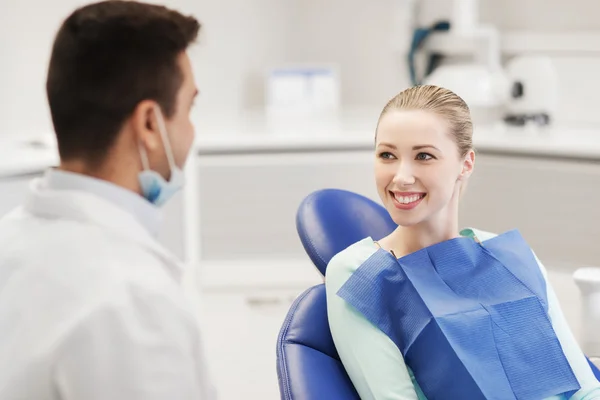Dentista masculino feliz con paciente mujer en la clínica — Foto de Stock
