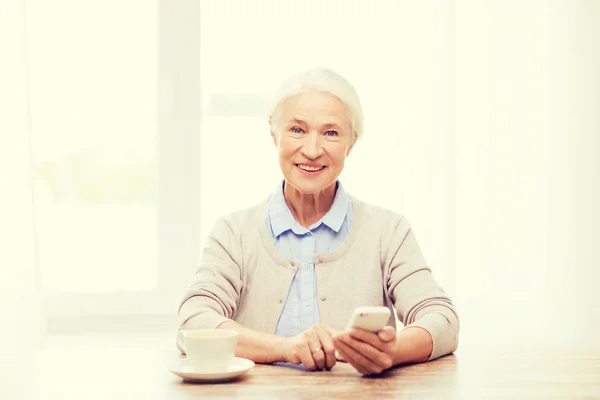 Seniorin mit Smartphone-SMS zu Hause — Stockfoto