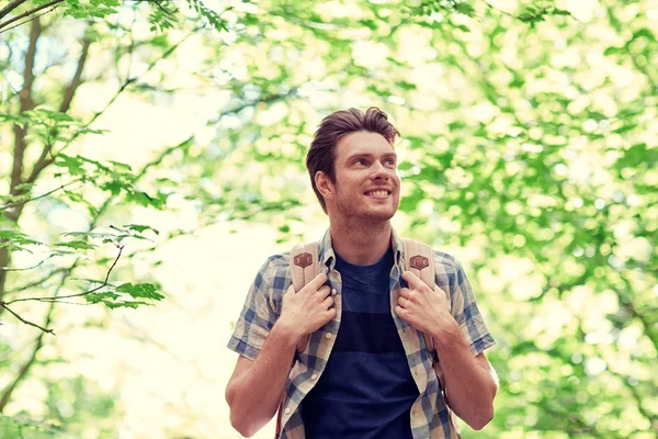 Sonriente joven con mochila senderismo en el bosque — Foto de Stock