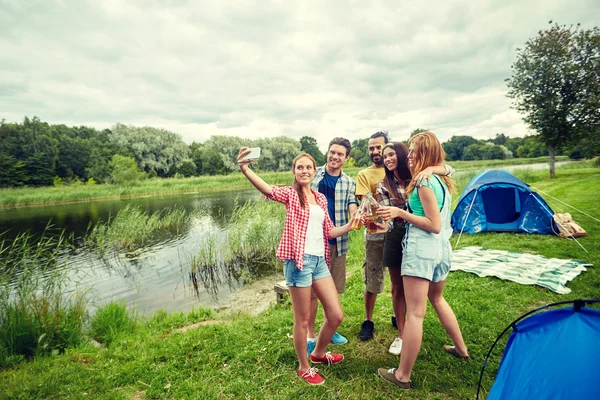 Amigos felices tomando selfie por teléfono inteligente en el campamento —  Fotos de Stock
