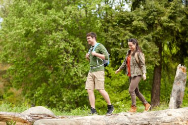 happy couple with backpacks hiking outdoors clipart