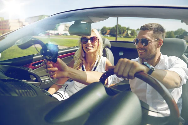 Lyckliga paret med gps navigator i cabriolet bil — Stockfoto