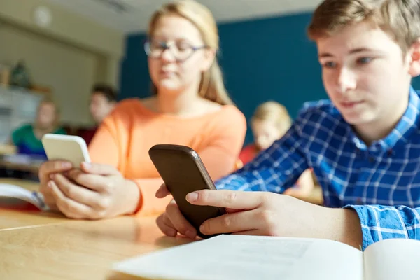 Middelbare scholieren met smartphones texting — Stockfoto