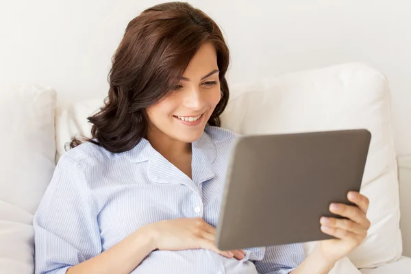 Mulher grávida feliz com tablet pc em casa — Fotografia de Stock