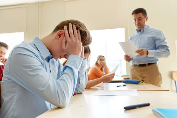 Teacher giving test results to group of students — Stock Photo, Image