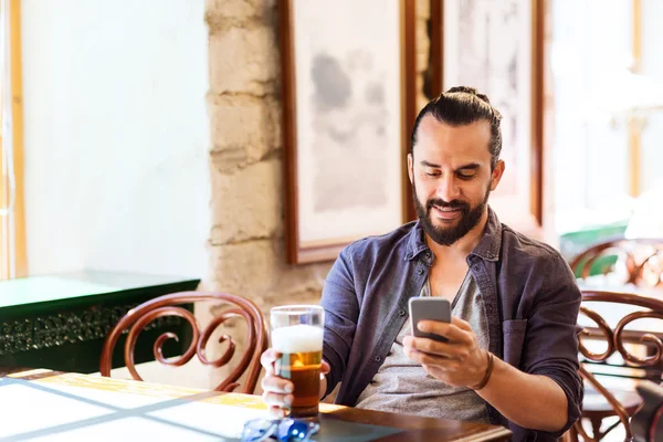 Ember iszik sört smartphone bárban vagy kocsmában — Stock Fotó