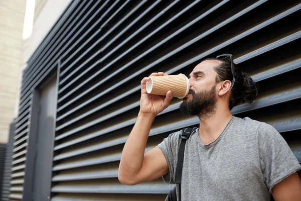 Człowiek pije kawę z papierowy kubek na ulicy — Zdjęcie stockowe