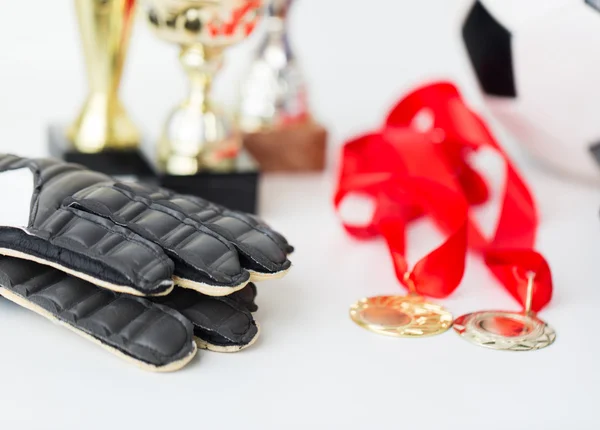 Close up of football, gloves, cups and medals — Stock Photo, Image