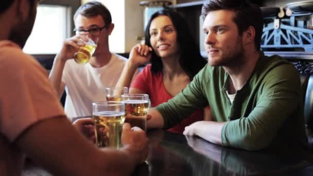 Счастливые друзья пьют пиво в баре или пабе — стоковое видео