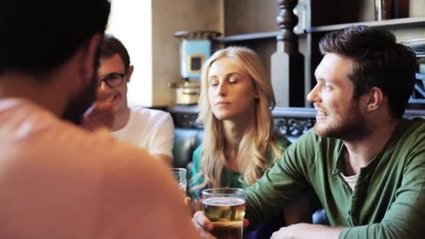 Счастливые друзья пьют пиво в баре или пабе — стоковое видео