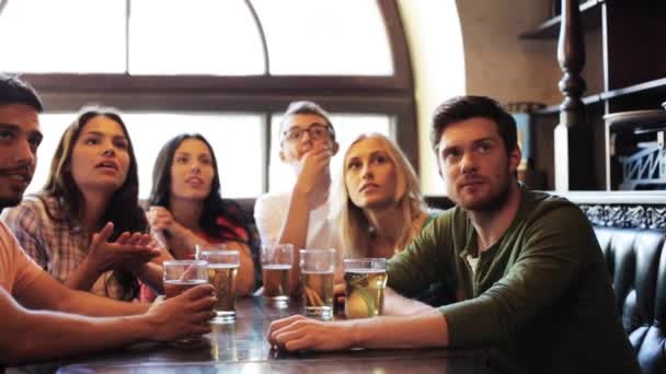 Amigos con cerveza viendo fútbol en un bar o pub — Vídeos de Stock