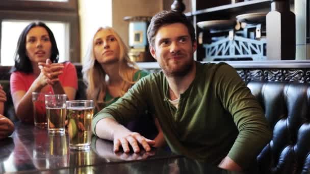 Amigos com cerveja assistindo futebol no bar ou pub — Vídeo de Stock