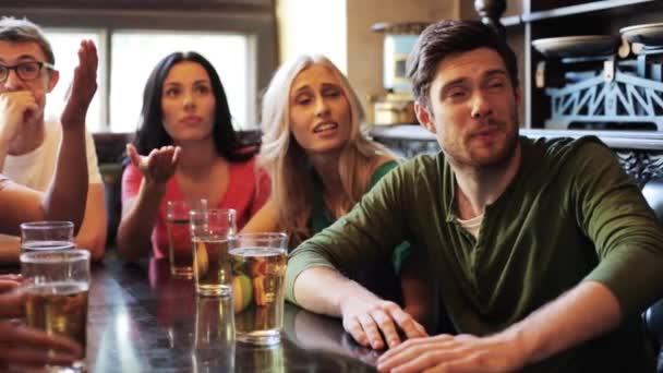 Друзья с пивом смотрят футбол в баре или пабе — стоковое видео