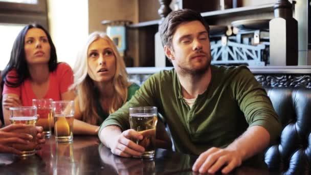 Amigos com cerveja assistindo futebol no bar ou pub — Vídeo de Stock