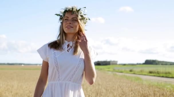 Feliz joven en corona de flores en el campo de cereales — Vídeo de stock