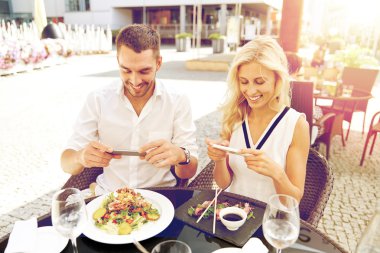 happy couple with smatphone photographing food clipart