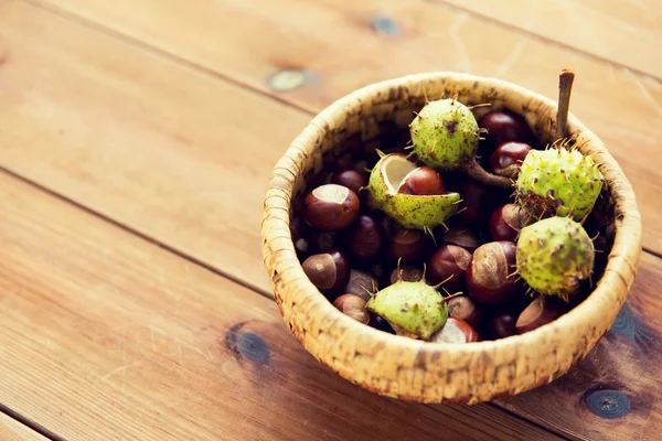 Close-up de castanhas em cesta na mesa de madeira — Fotografia de Stock