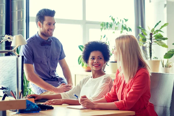 Gelukkig creatieve team praten in office — Stockfoto