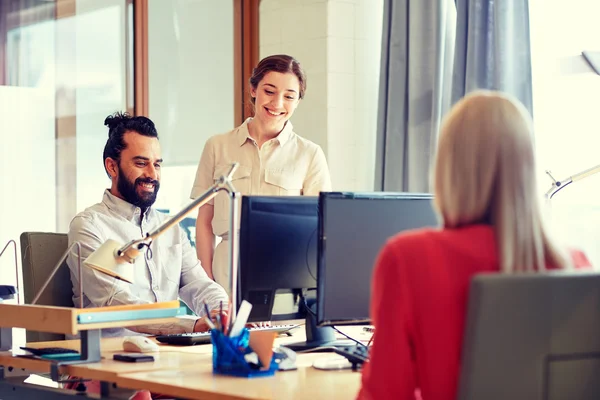 Equipe criativa feliz com computadores no escritório — Fotografia de Stock