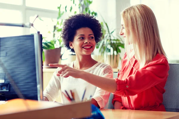 Glückliche Frauen oder Studenten mit Computer im Büro — Stockfoto