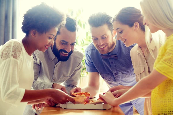 Equipe de negócios feliz comer pizza no escritório — Fotografia de Stock