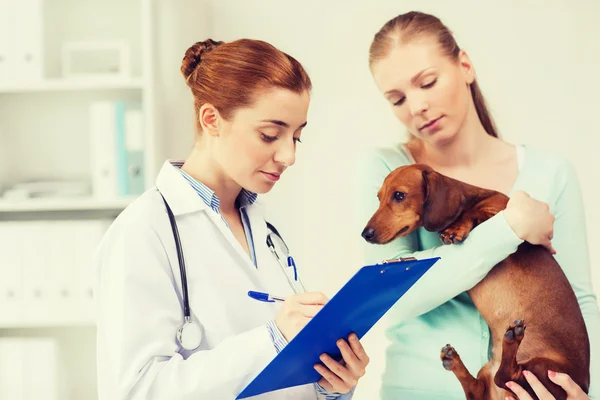 Женщина с собакой и врач в ветеринарной клинике — стоковое фото