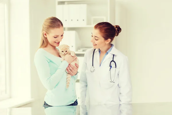 Mulher feliz com gato e médico na clínica veterinária — Fotografia de Stock