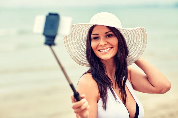 Uśmiechnięta młoda kobieta robi selfie ze smartfonem — Zdjęcie stockowe