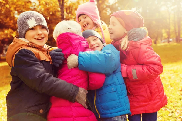 Mutlu çocuk sonbahar parkta sarılma grup — Stok fotoğraf