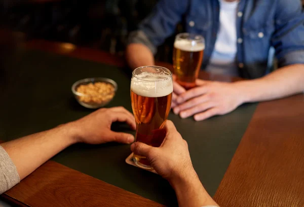 close up of men drinking beer at bar or pub