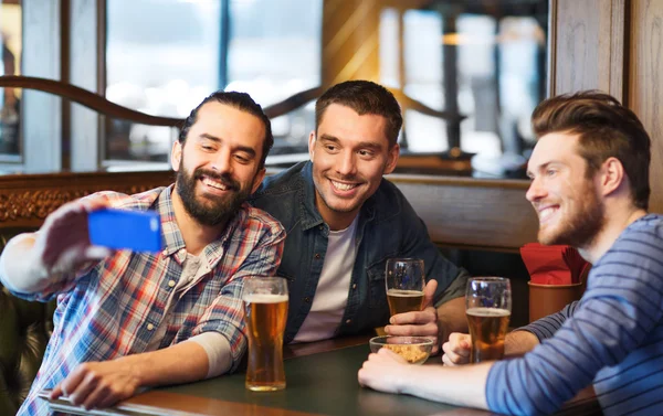 Amigos tomando selfie e beber cerveja no bar — Fotografia de Stock