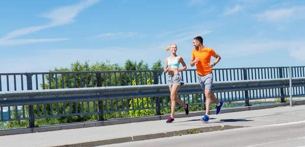 Smiling couple running at summer seaside — Stock Photo, Image