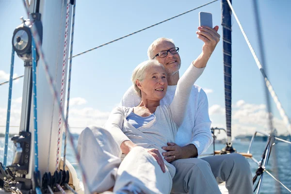 Seniors con smartphone tomando selfie en yate —  Fotos de Stock